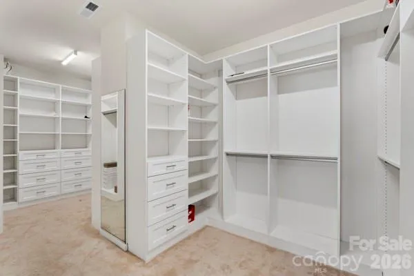 a view of walk in closet with empty racks
