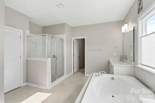 a en suite bathroom with a tub sink and mirror