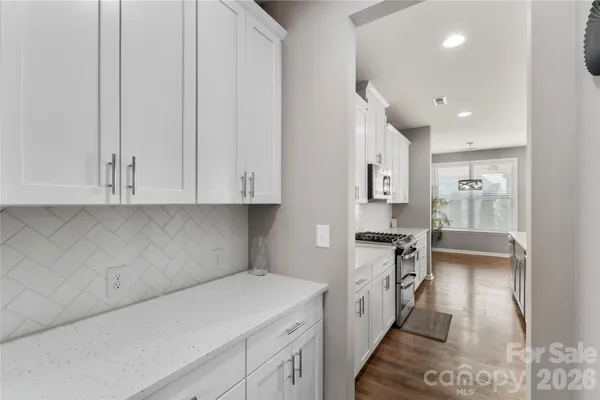 a kitchen with granite countertop white cabinets and white appliances