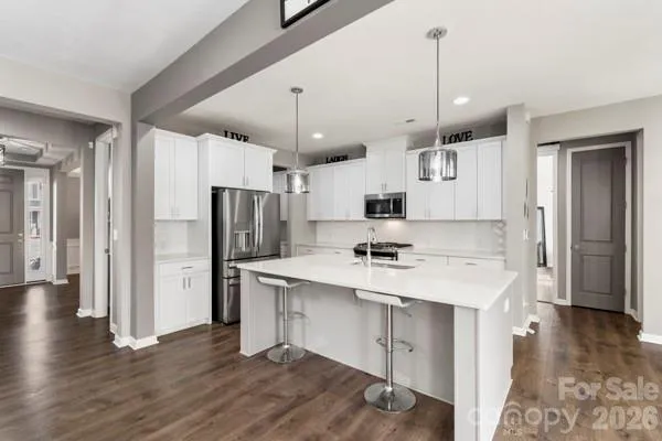 a kitchen with stainless steel appliances kitchen island a sink a refrigerator and a oven