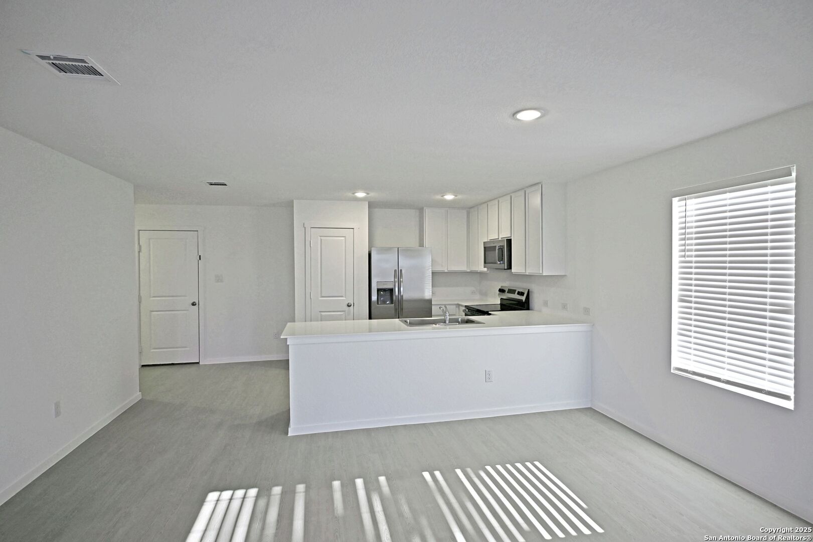 3837 Low Tide Seguin, TX 78155 - Photo 10 of 20 a large white kitchen with kitchen island a sink wooden floor and white cabinets