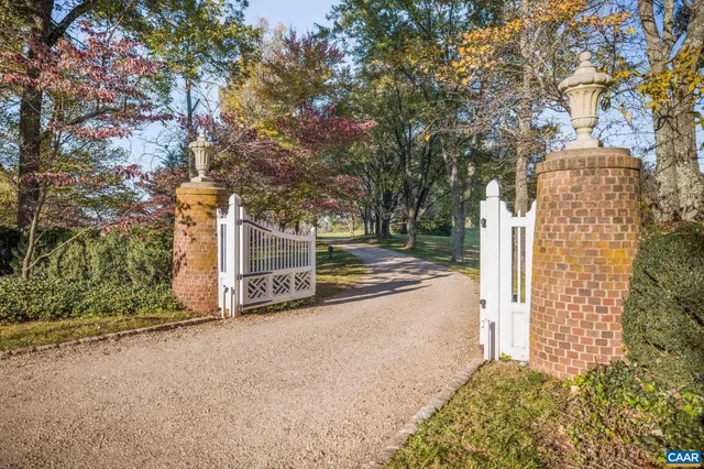a front view of a house with a yard and large trees