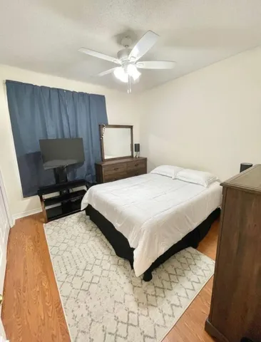 a bedroom with a bed and dresser with mirror
