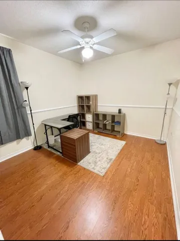 a kitchen with stainless steel appliances a stove a refrigerator a sink a dining table and chairs with wooden floor