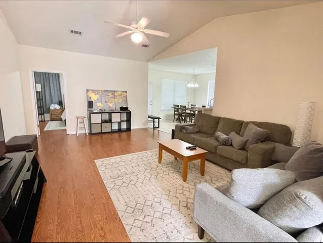 a living room with furniture and wooden floor