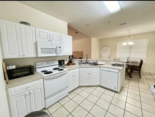 a kitchen with white cabinets appliances and a sink
