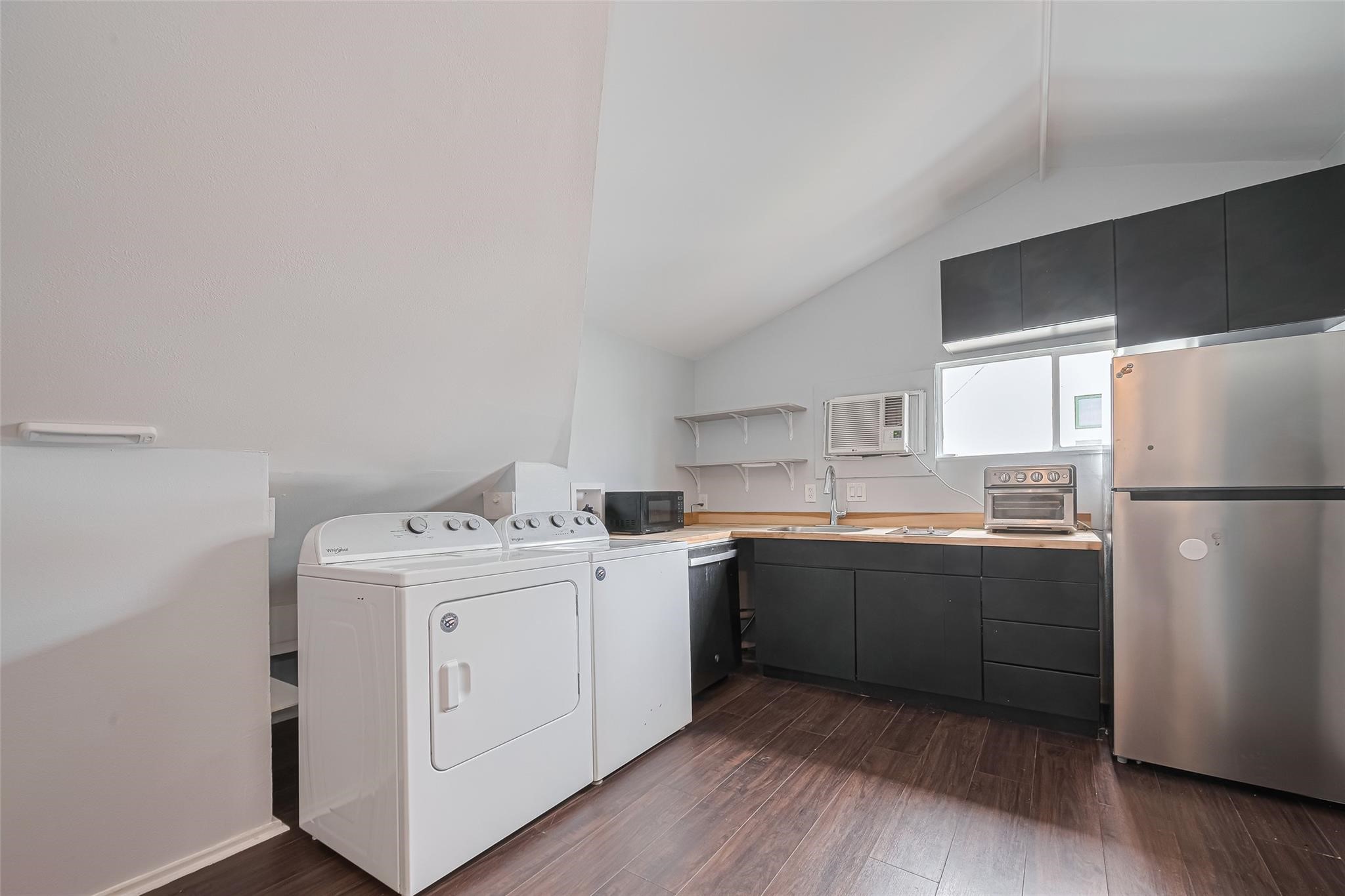 845 Columbia Street, Unit C Houston, TX 77007 - Photo 3 of 12 a kitchen with a sink a refrigerator and white cabinets