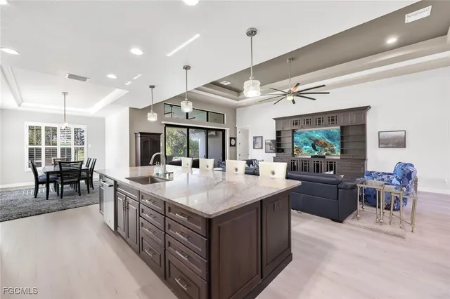 a large kitchen with a counter space a sink appliances and dining table
