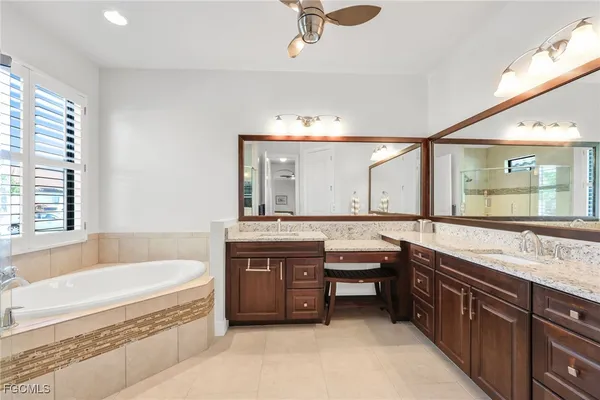 a spacious bathroom with a granite countertop tub double vanity and a sink