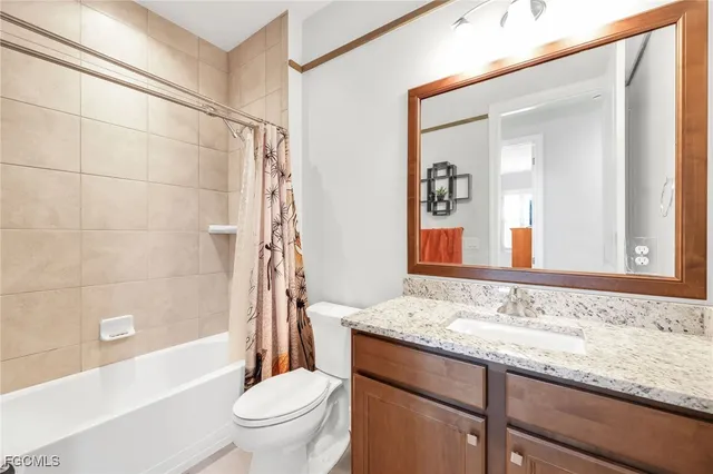 a bathroom with a granite countertop sink a toilet and shower