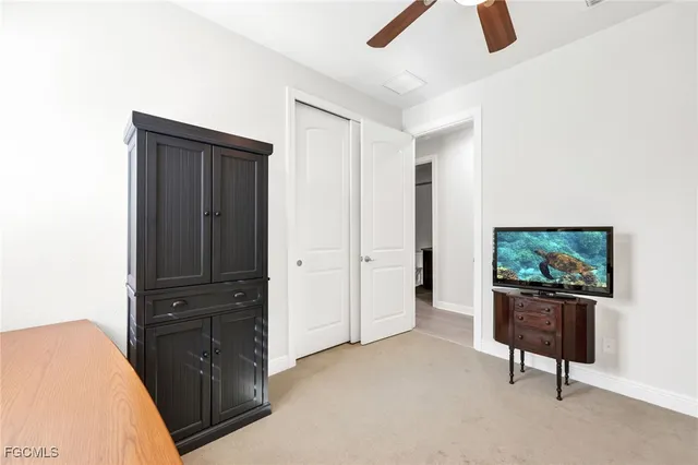 an empty room with ceiling fan and window