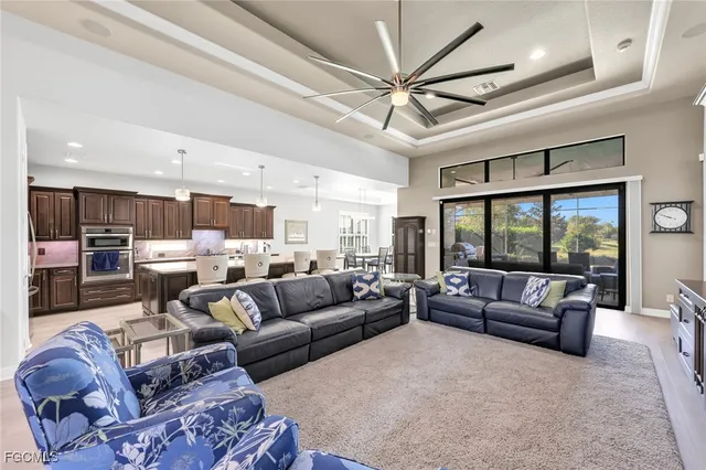 a living room with furniture kitchen view and a large window