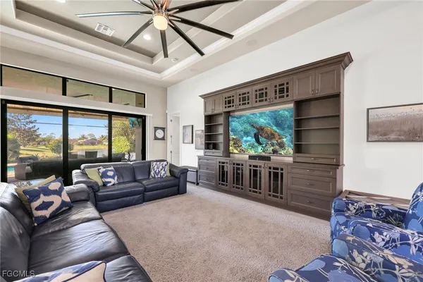 a living room with furniture a flat screen tv and a large window