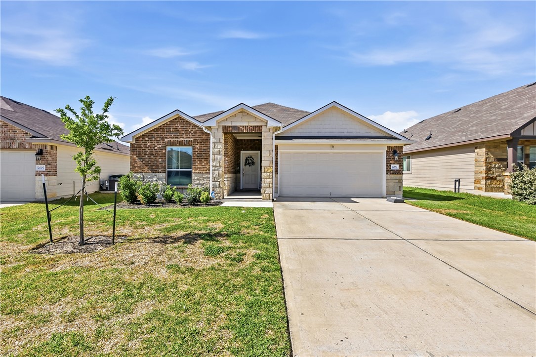 a front view of a house with a yard and garage
