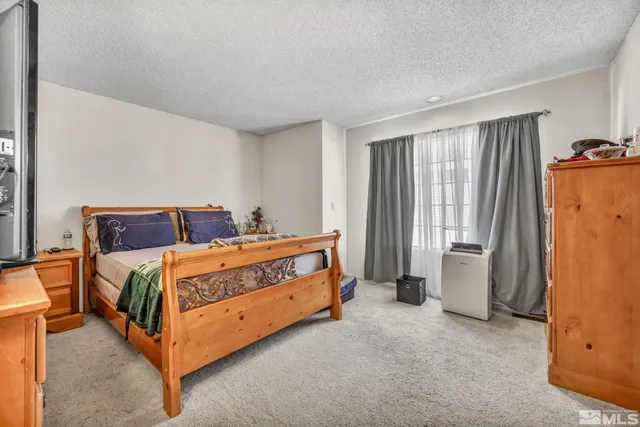 a bed sitting in a room with a dresser and mirror