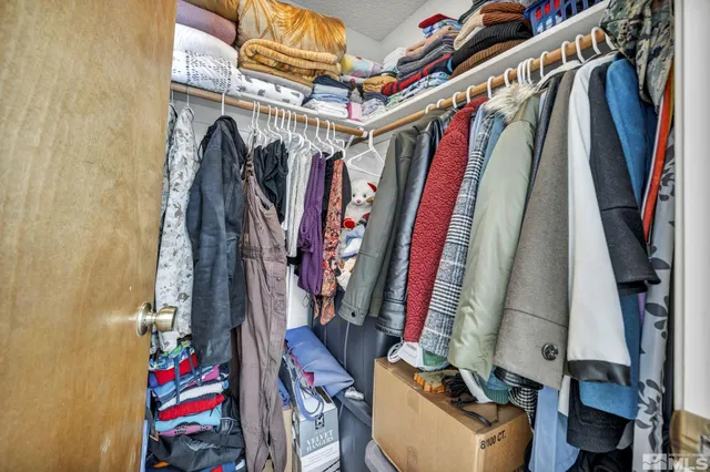 a view of walk in closet with clothes
