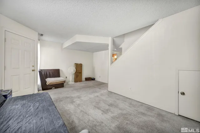 a large bedroom with a bed and wooden floor