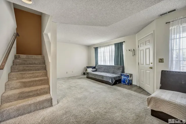 a view of a livingroom with furniture and staircase