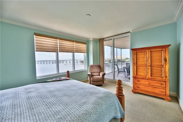 a bedroom with a bed and large windows