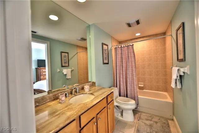 a bathroom with a granite countertop sink toilet a large mirror a shower and a bathtub