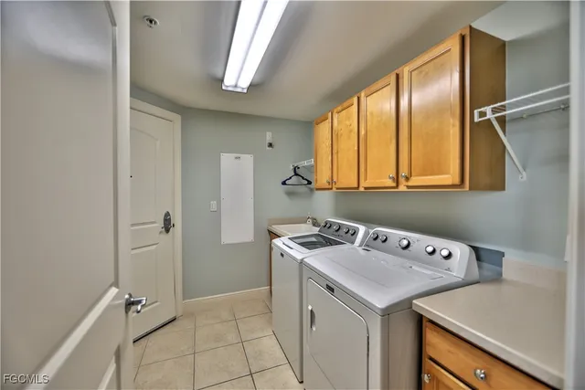 a utility room with cabinets washer and dryer