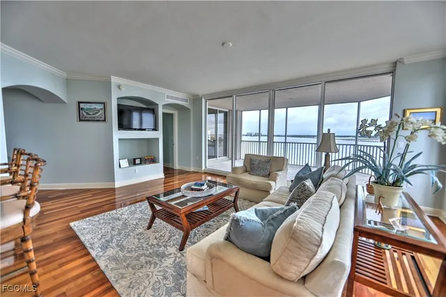 a living room with furniture a rug and a floor to ceiling window