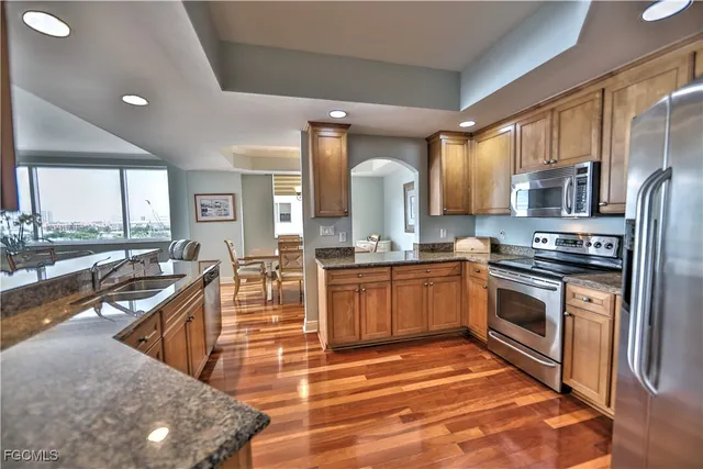 a kitchen with stainless steel appliances granite countertop a stove a sink and a microwave