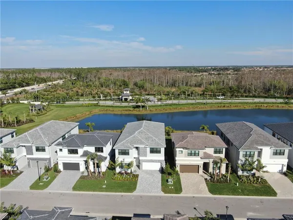 a view of house with swimming pool and trees in the background