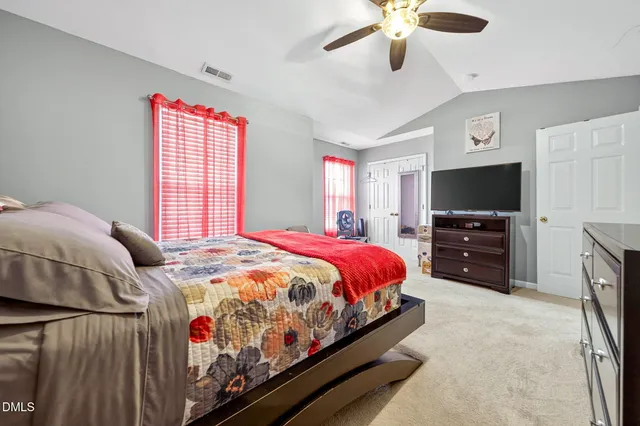 a bedroom with a bed a chandelier and a flat screen tv