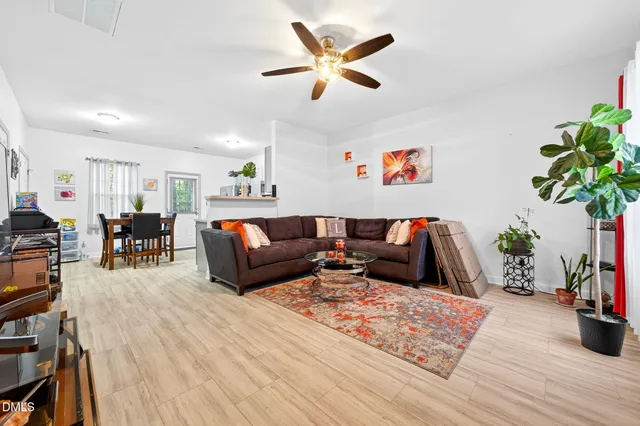 a living room with furniture potted plant and wooden floor