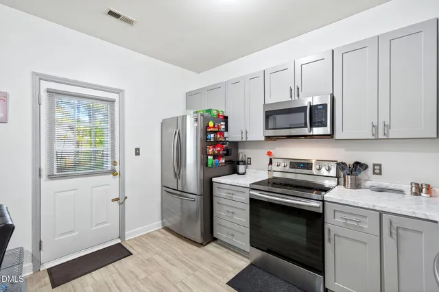 a kitchen with stainless steel appliances granite countertop a refrigerator stove and sink