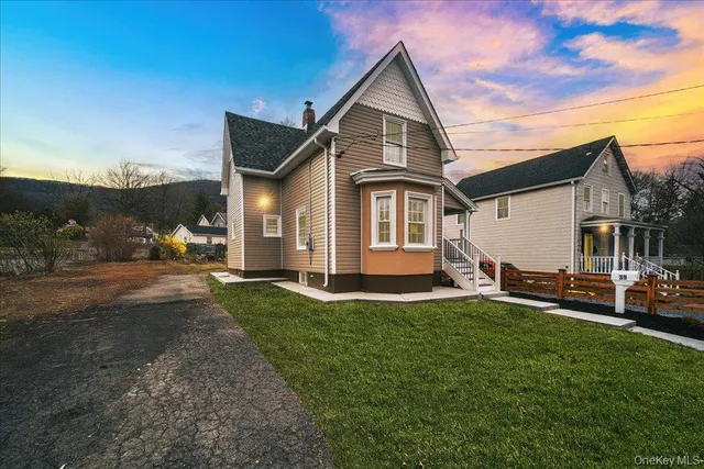 a front view of a house with a garden and yard