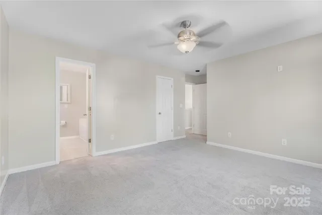 a view of an empty room with a chandelier fan