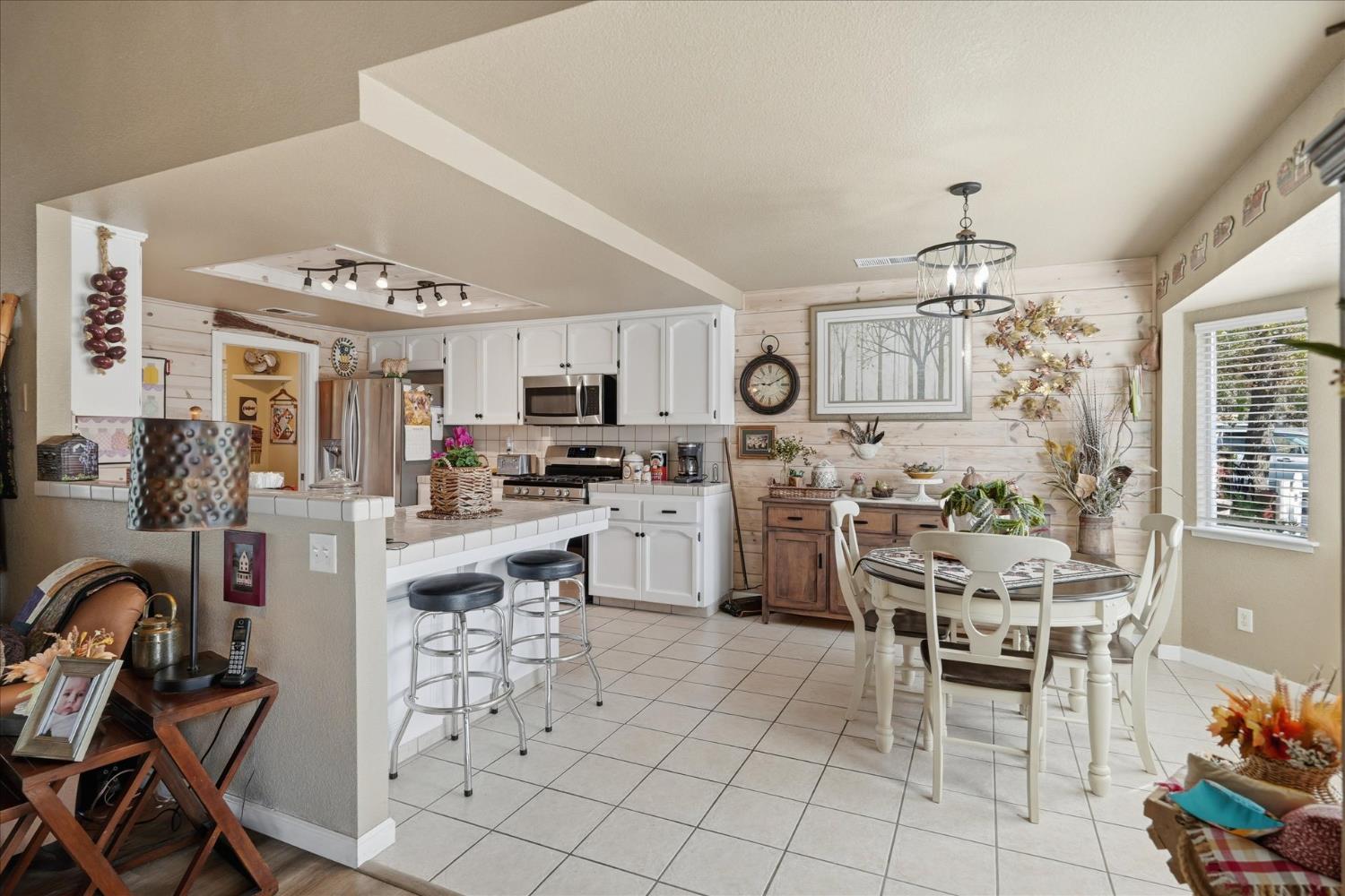 32583 River Knolls Road Coarsegold, CA 93614 - Photo 19 of 63 a kitchen with stainless steel appliances kitchen island granite countertop a refrigerator and microwave