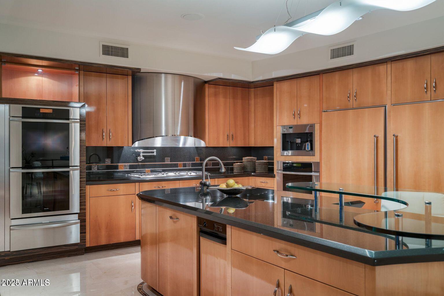 4550 East Foothill Drive Paradise Valley, AZ 85253 - Photo 14 of 58 a kitchen with granite countertop stainless steel appliances and wooden cabinets