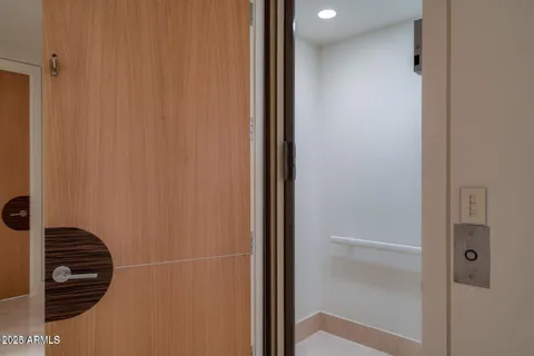 a view of pool with lawn chairs and floor to ceiling window