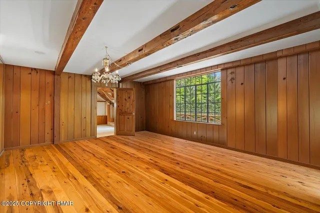 a view of a livingroom with a fireplace wooden floor and chandelier