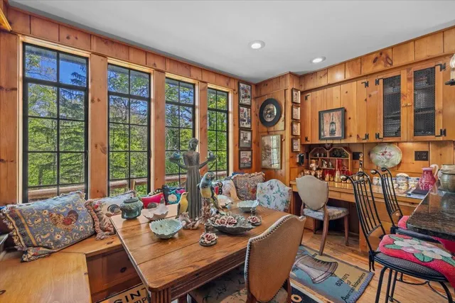 a kitchen with stainless steel appliances granite countertop a refrigerator a sink dishwasher a stove and a dining table with wooden floor