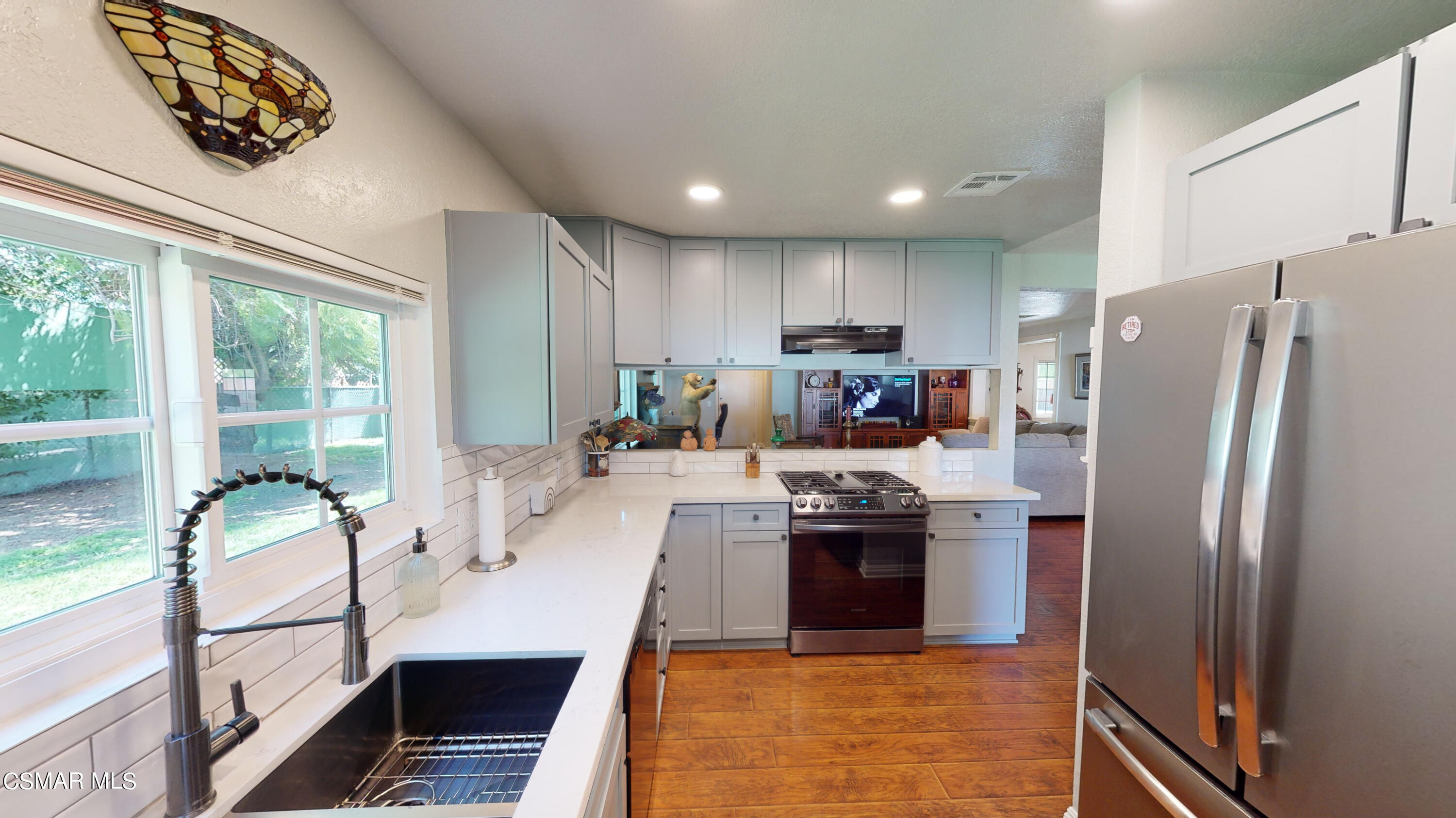 4865 Leeds Street Simi Valley, CA 93063 - Photo 19 of 91 a large kitchen with stainless steel appliances a large counter top a stove a refrigerator a sink dishwasher and cabinets