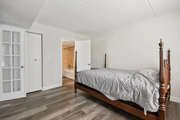 a bedroom with a bed and wooden floor