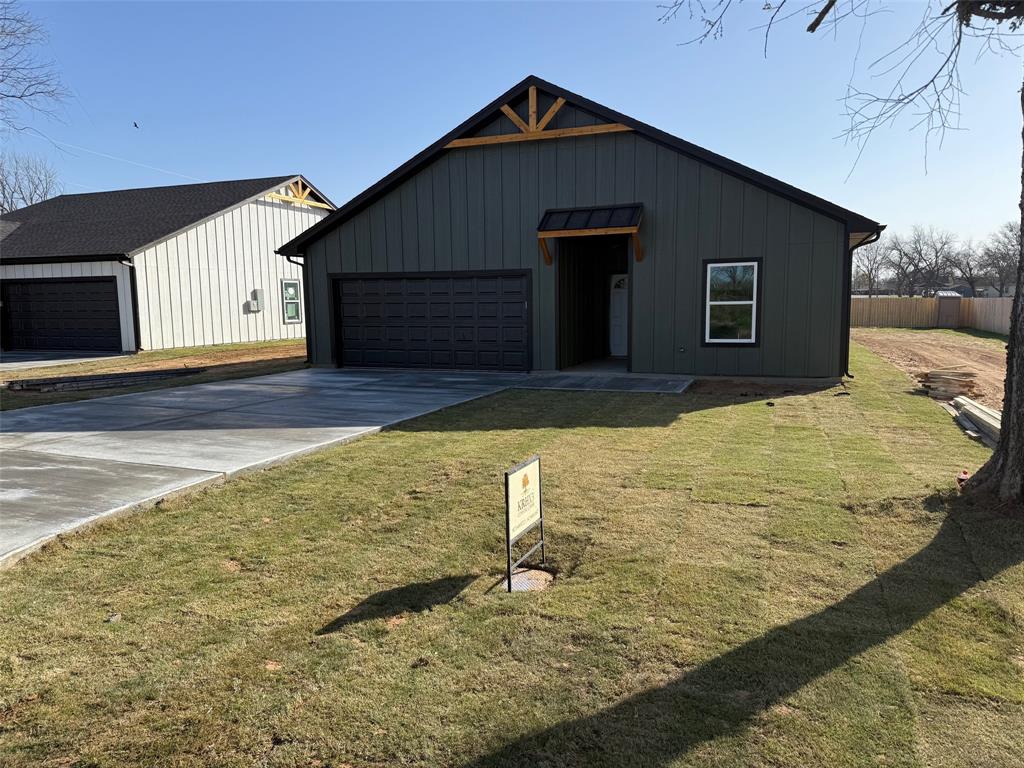 307 Pecan Lane Tolar, TX 76476 - Photo 1 of 1 Modern farmhouse featuring an outdoor structure, board and batten siding, a front yard, and fence
