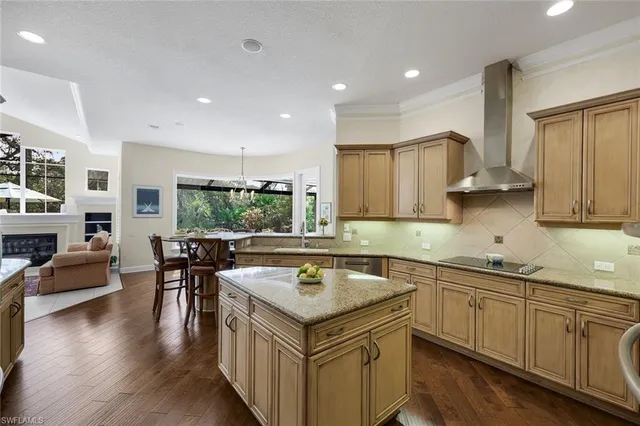 a kitchen with a stove a sink a kitchen island with a dining table and chairs