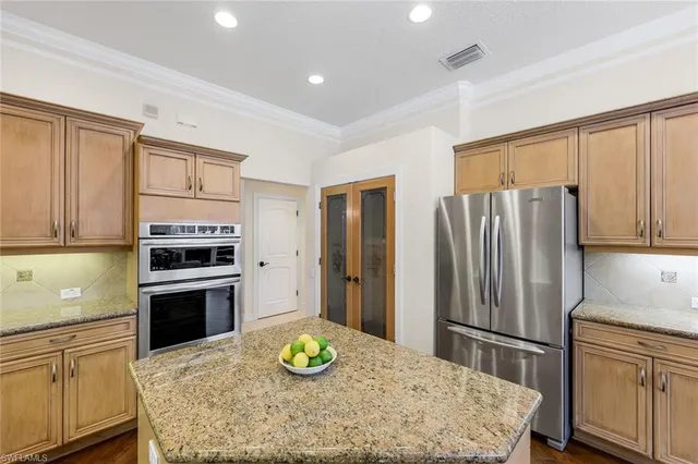 a kitchen with a refrigerator and a stove top oven