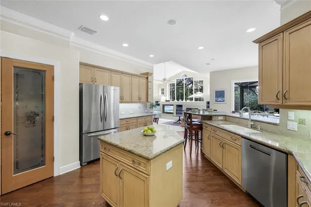 a kitchen with stainless steel appliances granite countertop a refrigerator a sink and a stove