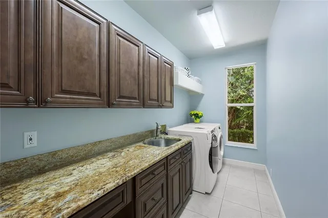 a utility room with granite countertop cabinets washer and dryer