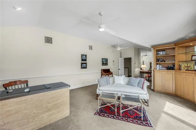 a living room with furniture and a dining table with kitchen view