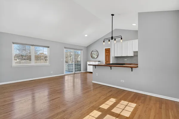 a view of empty room with wooden floor and window