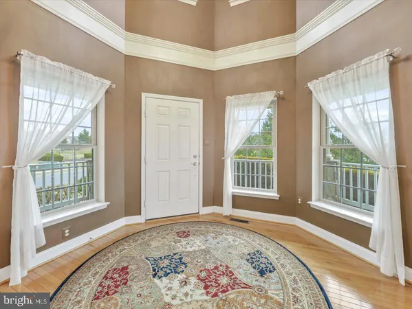 a living room with wooden floor and a window