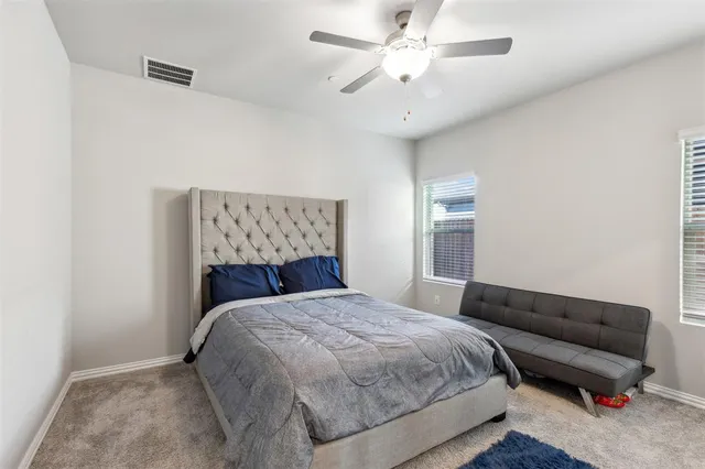 a bedroom with a bed and a ceiling fan