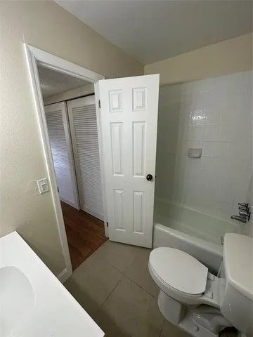 a bathroom with a sink a toilet a tub and shower